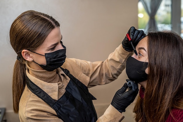 A new makeup artist invited a young client in a special mask for makeup during a pandemic