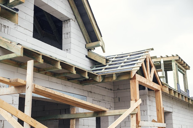 New modern farmhouse constructionWooden roof framing with vapor barrier on block walls with windows