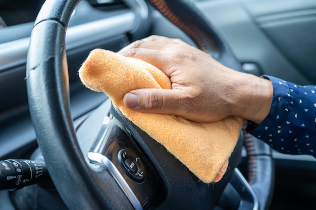 New Normal Asian working woman clean in car by press blue alcohol sanitizer gel for protect safety Coronavirus