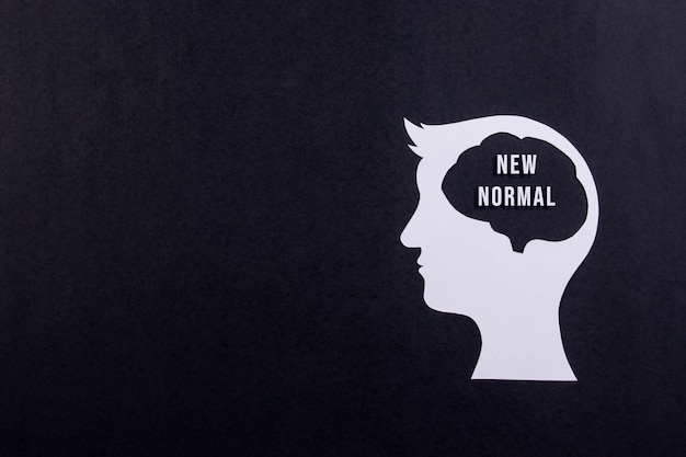 New normal concept after covid-19 pandemic. Human head with text on black background.