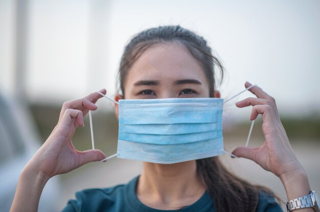 New normal Woman wearing a dust mask and Corona virus Before traveling to various places in daily life