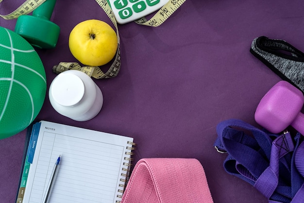 new perfect equipment together with a notebook and a pen are scattered on colored mats. The concept of goals in sports. Notepad concept with goals in sport