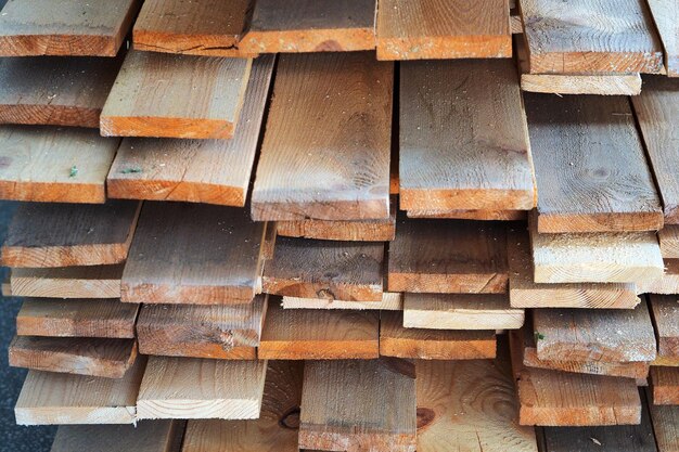 New planed wooden boards stacked in sawmill Procurement and sale of building material Dry wood Woodworking Background