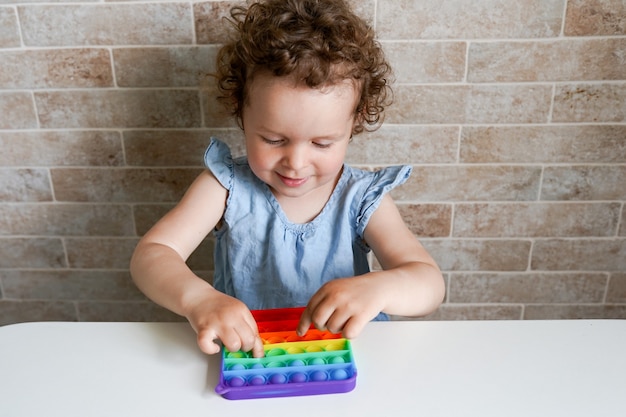 New popular silicone popit toy, baby is playing with it. Development of fine motor skills