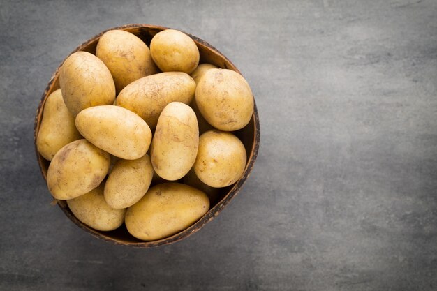 New potato on the bowl, gray background.