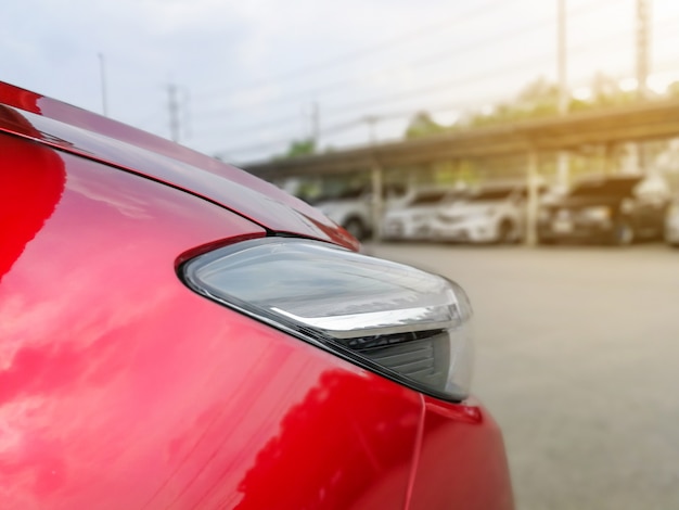 New red car in the parked with many cars on parking lot 