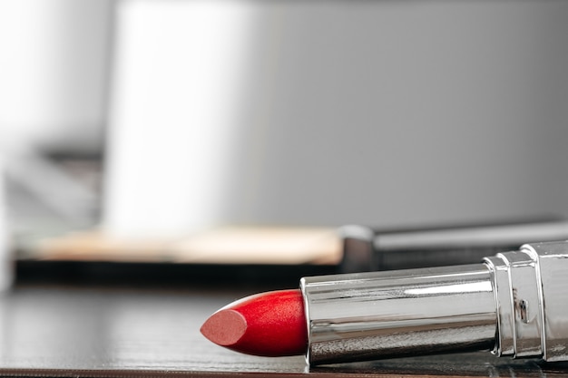 New red lipstick on vanity table close up