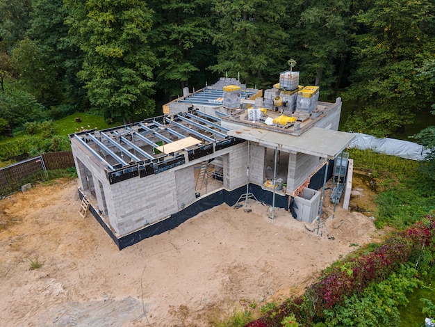 New residential house under construction with cinder blocks and building materials in a wooded area