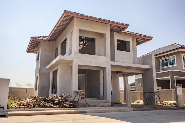 New residential house contemporary style building in progress at construction site with blue sky