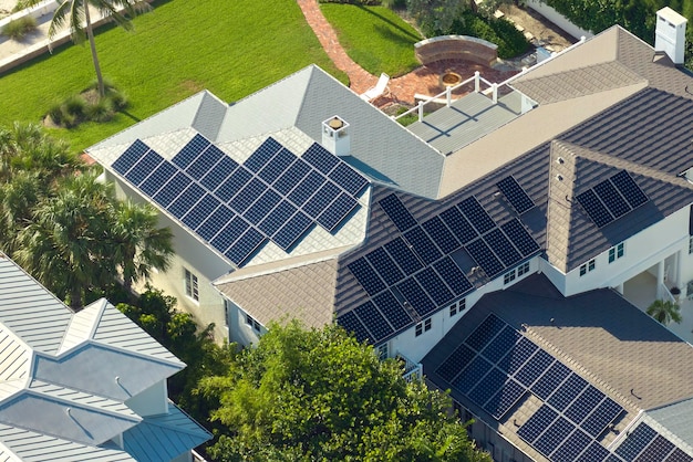 New residential house in USA with roof covered with solar panels for producing of clean ecological electricity in suburban rural area Concept of investing in autonomous home for energy saving