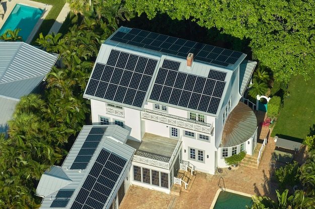 New residential house in USA with roof covered with solar panels for producing of clean ecological electricity in suburban rural area Concept of investing in autonomous home for energy saving