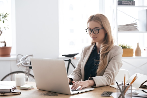 new solution every day. confident young woman in smart casual wear working on laptop 