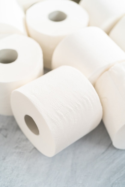 New white toilet paper rolls on a gray background.