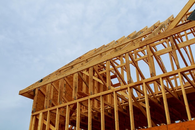 A new wooden frame on a house under construction in a blue sky