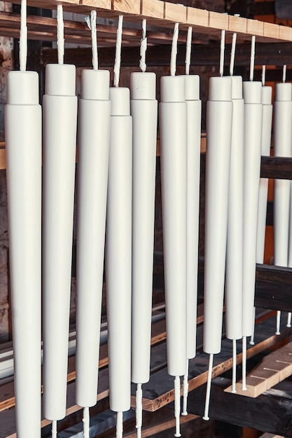 New wooden furniture legs drying after applying paint leaned on large rack in light woodwork shop