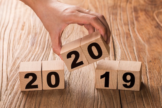 Photo new year 2019 change to 2020 hand change wooden cubes.