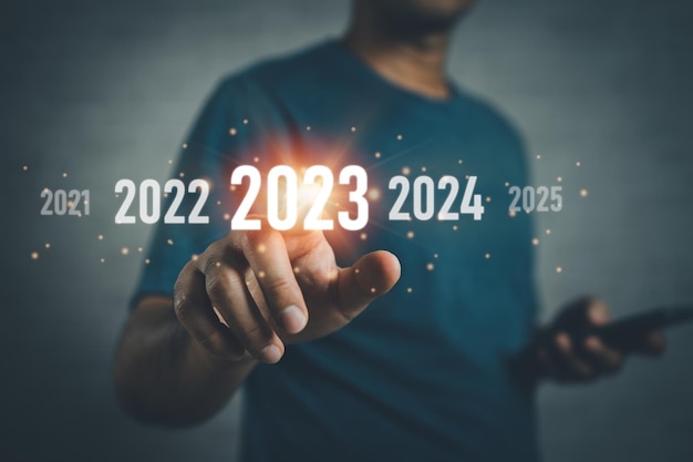 New Year 2023 concept Start happy new year 2023 Businessman investors using and mobile phone finger touch screen virtual 2023 year diagram business planning strategy business trends investment