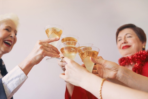 new year celebrating hands with glasses of white sparkling wine