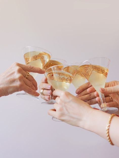 new year celebrating hands with glasses of white sparkling wine