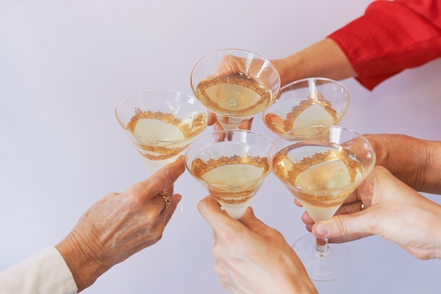 new year celebrating hands with glasses of white sparkling wine