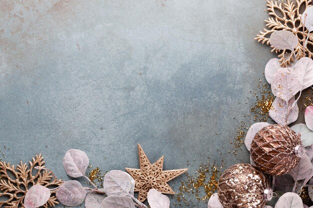 New Year celebration and Christmas background with golden flowers, snow, stars and Christmas decorations top view.