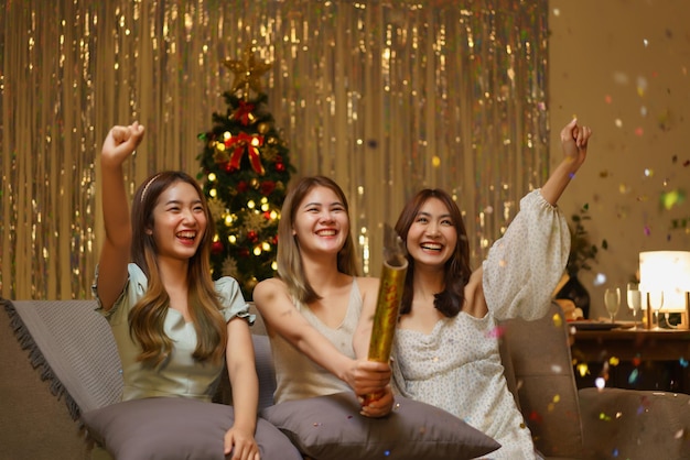 New Year celebration concept Young beautiful group shooting confetti firework poppers with fun