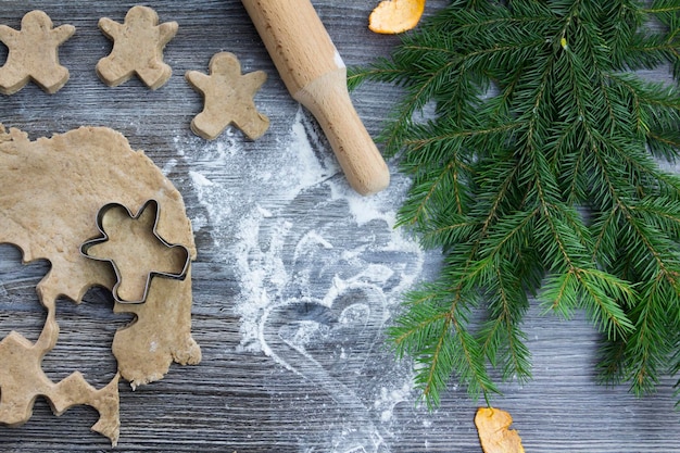 New Year and Christmas decorations on a wooden surface with tangerines and a Christmas tree Prepare sweets in the form of ginger cookies and gingerbread for the celebration of Christmas