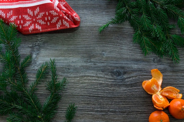 New Year and Christmas decorations on a wooden surface with tangerines and a green Christmas tree