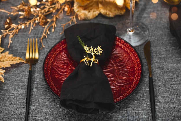 New Year and Christmas table setting Red empty plate and linen napkin on festive christmas table