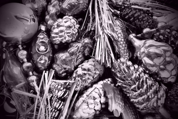 New Year and Christmas tree decorations glass balls in the form of cones and baskets Cones and pendants shiny tinsel Festive background Lots of Christmas decorations Black and white monochrome