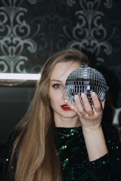 New year eve night club party chic image of beautiful girl in sparkles evening dress with disco ball