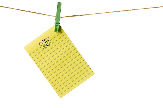 New Year New Goals Yellow Sticky Note Paper on a clothesline isolated on white To do list