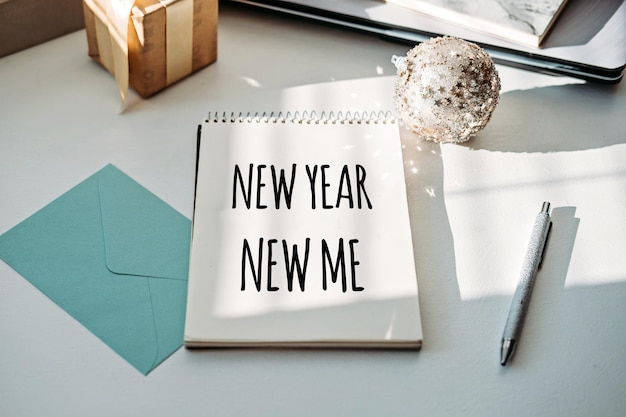 Photo new year new me text in open notepad on table at home setting goals and new years resolution new