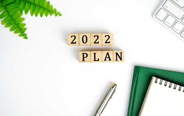 new year plan 2022 Plans keyboard notebook and pen 2022 PLAN word is written on wood block