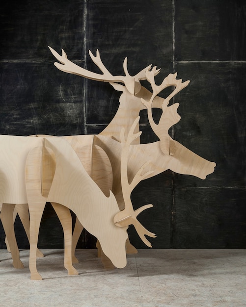 Photo new year's and christmas decoration deer made of plywood and wood on a dark background