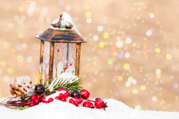 New Year's Christmas decoration a postcard, a flashlight, a branch of a fir tree with red berries and cones on a background of blurred lights.