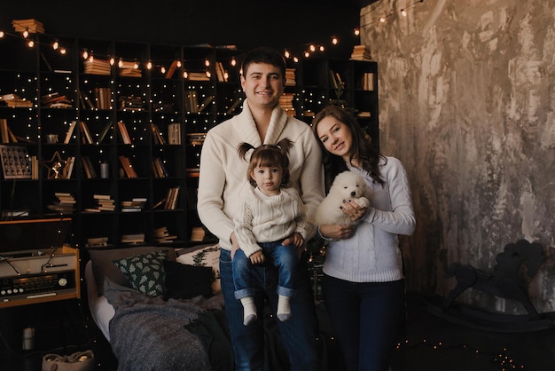 New Year's Christmas family photo session with a Samoyed puppy Mom dad daughter Happy family