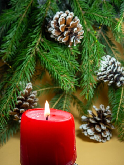 Photo new year's decorations pine cone candle and fir branches on a beige background new year