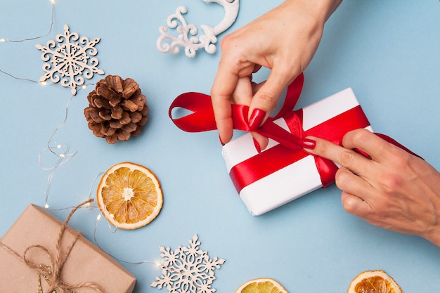 The New Year's flay lay with a gift box and womens hands. Christmas concept