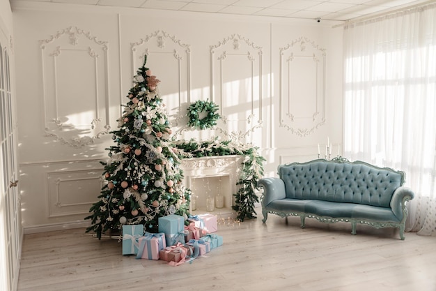 New Year's gifts in designer paper and bright ribbons under the Christmas tree on the floor on New Year's Eve Christmas tree decorated with toys stands near the fireplace