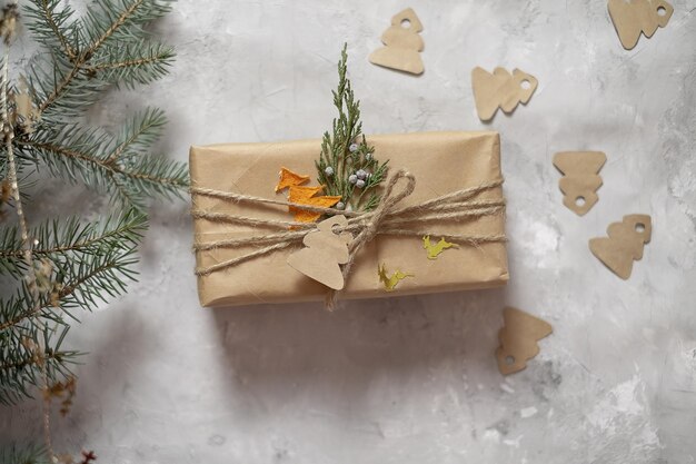 New Year's gifts packed in craft paper lie on a roofing sheet on a gray background