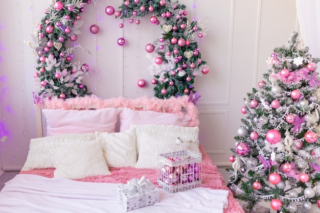 New year's interior of the house in pink, Christmas tree with balloons and a bed