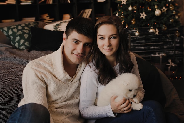 New Year's photo session with a couple in love with a Samoyed puppy