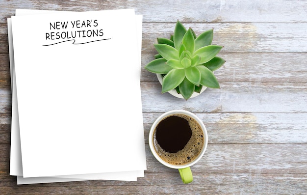 New year's Resolutions Text on notebook and coffee cup on office desk