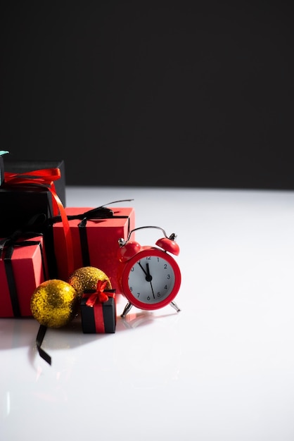 New Year's still life with watches and gifts on a whitedark background