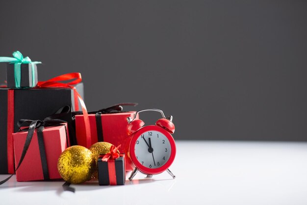 New Year's still life with watches and gifts on a whitedark background