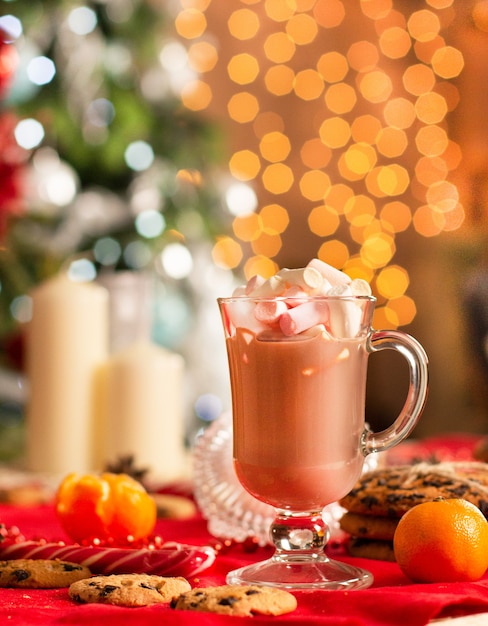 New Year's table decoration next to Christmas tree with beautiful luminous yellow blurs . 