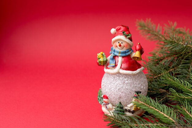 New year snowman with fir tree on red , copyspace. christmas holidays