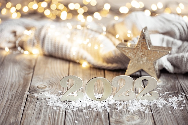 New year still life with decorative number of the coming year on a wooden surface against a blurred background.