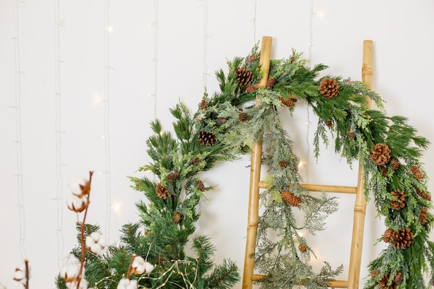 A New Year wreath from the branches of a Christmas tree hangs on the wall. Decorations in the house for the new year. Decorating the room for the New Year holidays